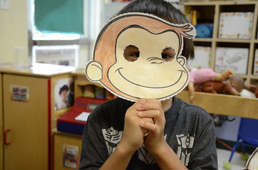 Kaeden Shouse, 6, shows off his Curious George mask.