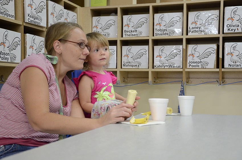Kendra Mackie and daughter Molley Jillson, 2, talk about Curious George.