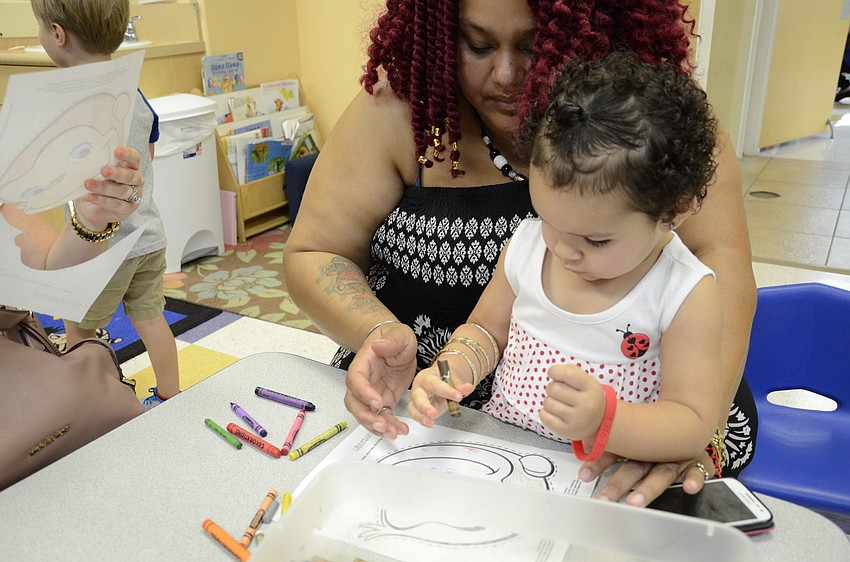Tawana Morgan helps her granddaughter, Ka'ja Crane, 2, color her mask.