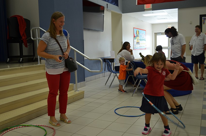 Finnley Jones plays with a hula hoop while her mother Mackenzie looks on.