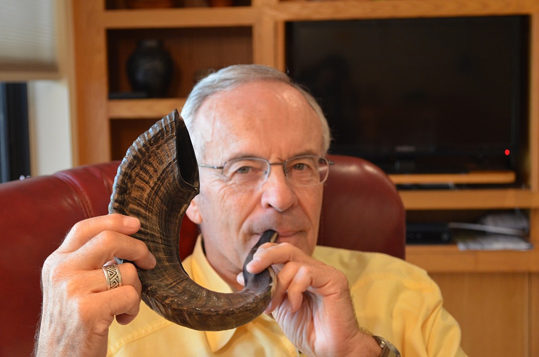 Lowell Lakritz blows into the shofar horn he brought back from his most recent trip to Israel.