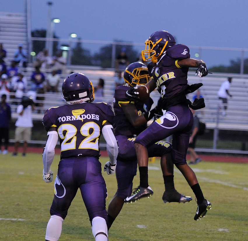 Members of the Booker High secondary celebrate following an interception.