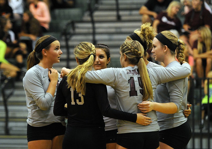 The Riverview High volleyball team huddles together during a timeout in the first set.