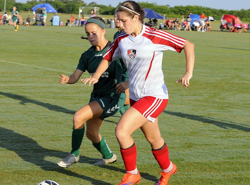 Cooper City Optimist's Danielle Gilchrist attempts to maneuver the ball past a Lakeland FC defender.