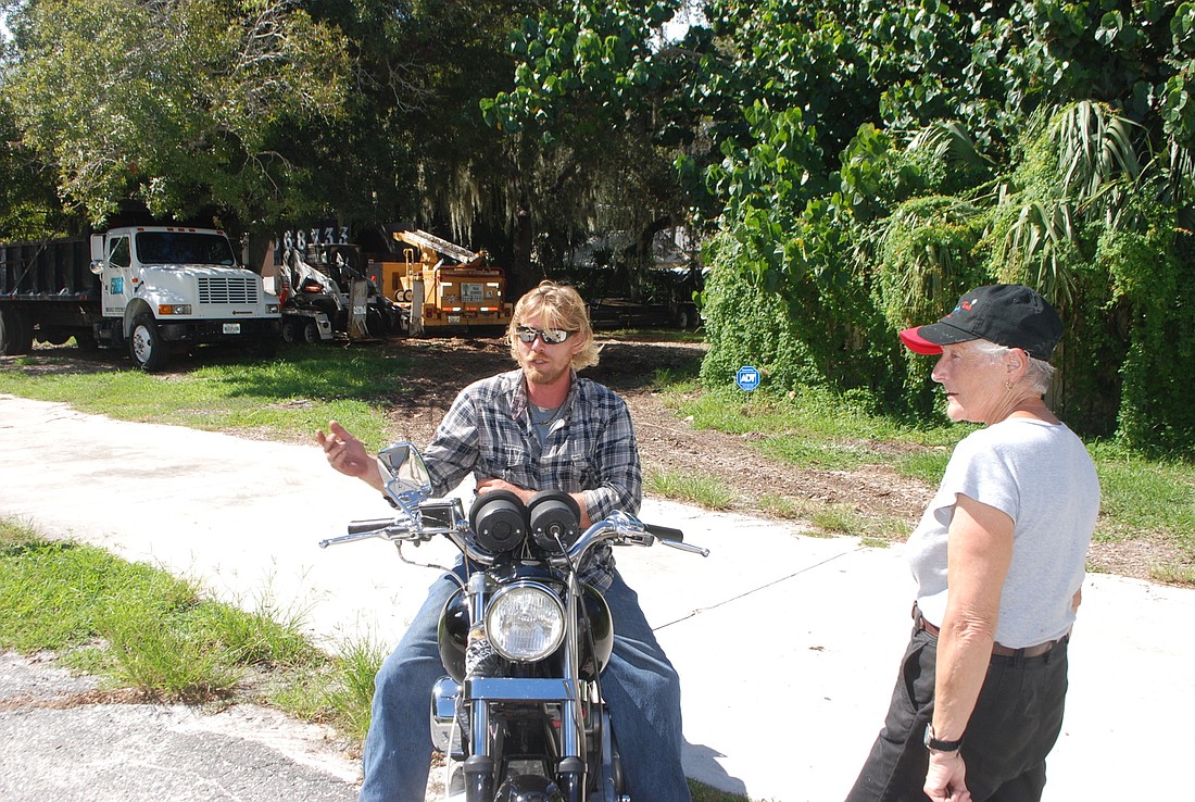 Neighbors Kakoszka (right) and Hazelewood (left) discuss Sarasota Crew's propose use of its property (background).