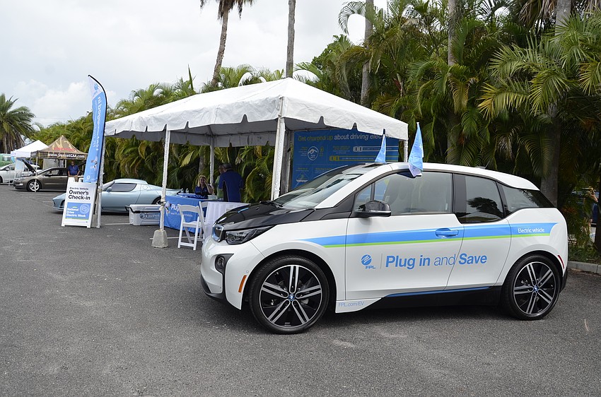 Florida Power and Light set up a tent with facts about the financial benefits and energy savings of electric vehicles and alternative energy solutions.