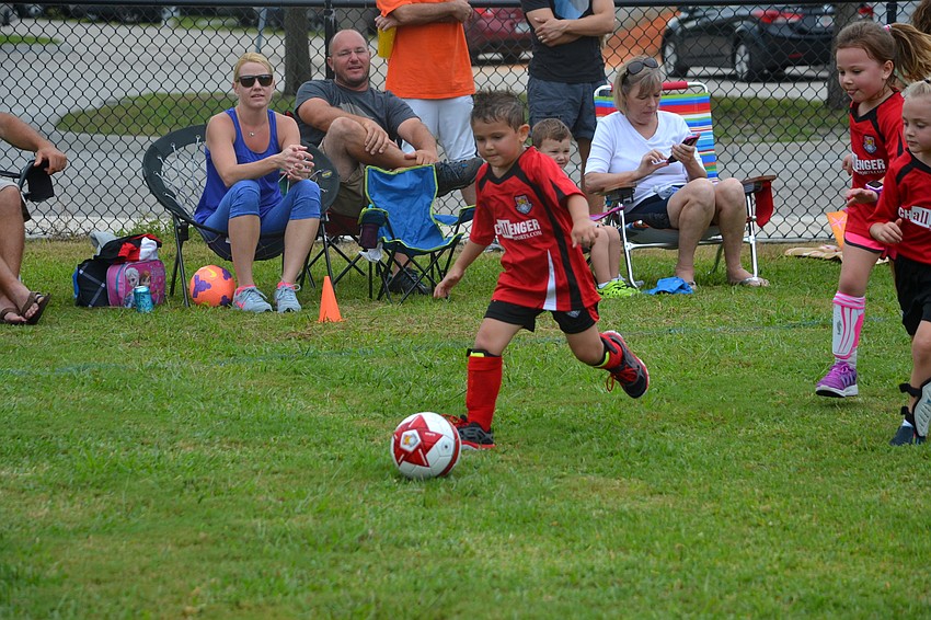Trevor Lujan chases after the soccer ball for the Goldfish team.