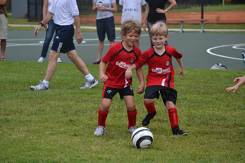Teammates Liam Walker and Rhys Parry chase after the ball.