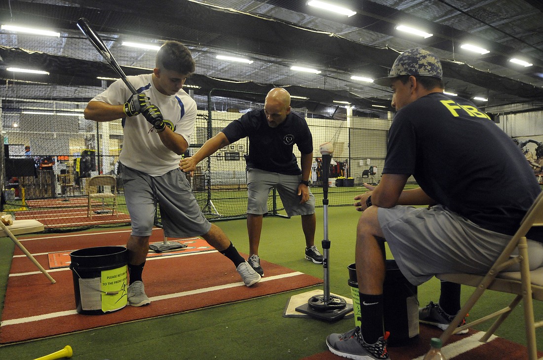 Senior middle infielder Nicolas Torres receives individual hitting instruction from Oscar Despada and Michael Rivera.