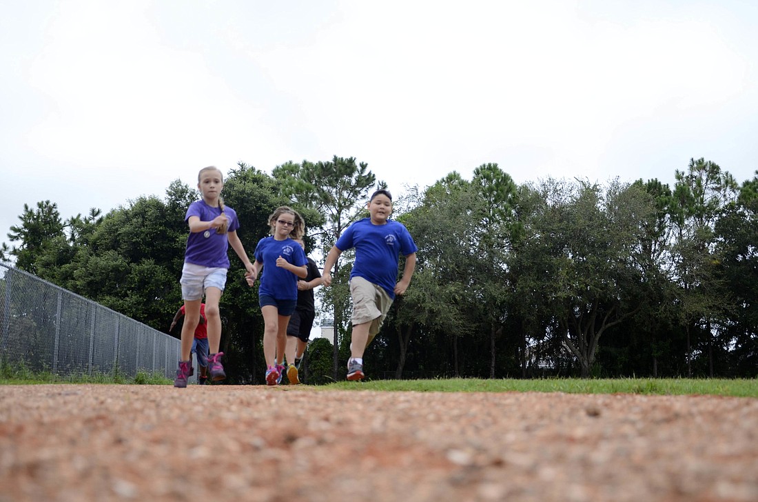 Fifth-graders Lauren Costello, Â Alexis Suter and Daniel Rumbo take a lap around the new track while learning about how to run at a steady pace.