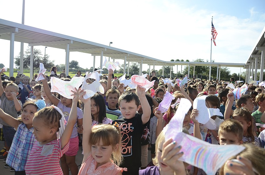 Students wave their Picasso doves during the Monday morning assembly.
