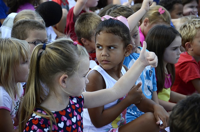 Kindergarteners Zsoka Moldovanyi and Taelynn Shabazz put their thumbs up after they thought of ideas for how to create peace in their lives.