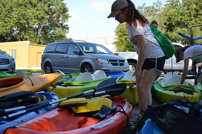 Emma Patten loads up her kayak before launching down Phillippi Creek.