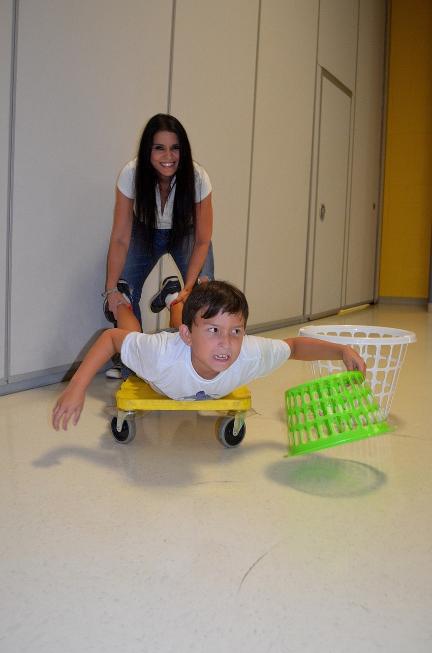 Yolanda Hughes pushes her son, Mark, toward balloons.