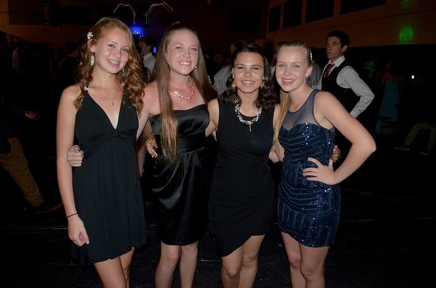 Kalli Johnson, Jalyn Thompson, Cienna Davis and Mackenzie Brielmann sport similar  knee-length dark dresses.
