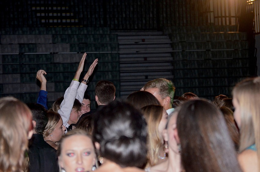 Students wave and clap their hands to the beat of the music.