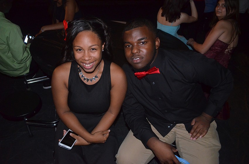 Kayla Bell and RaMonte Rome relax at a table with friends.