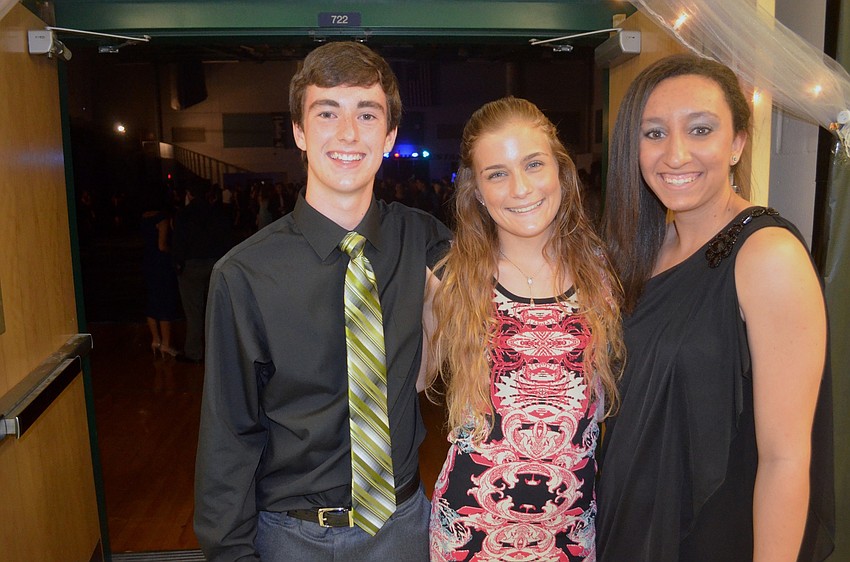 Kevin Mendel, Olivia Ogles and Elise Spiller wait in the hallway with friends before entering the main room.
