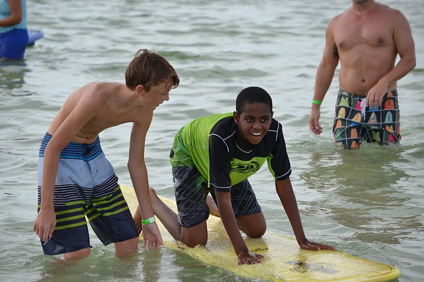 Volunteer Erik Epp guides Christian Garnes on the surfboard.