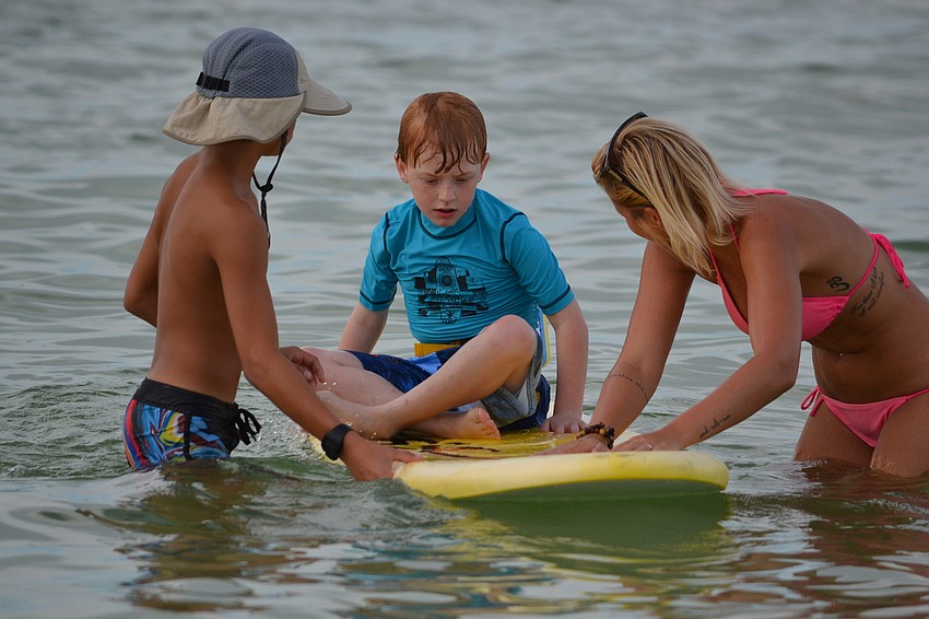 Isaac Armstrong receives surfing tips before taking on the waves.