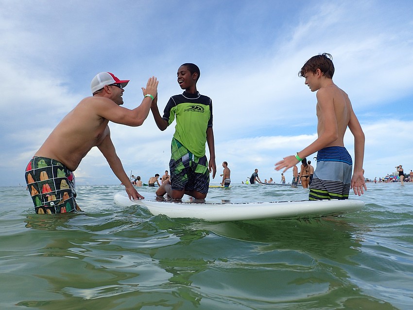 Jimmy Raybon congratulates Christian Garnes for standing up on a wave.