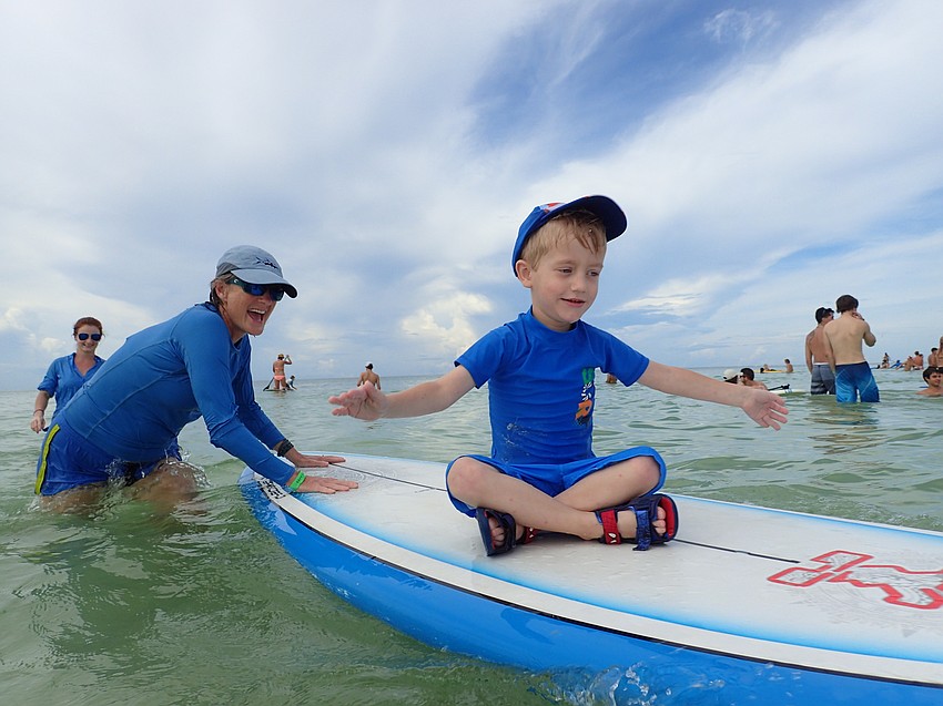 Volunteer Ally Royal guides Benjamin Armstrong on a wave.