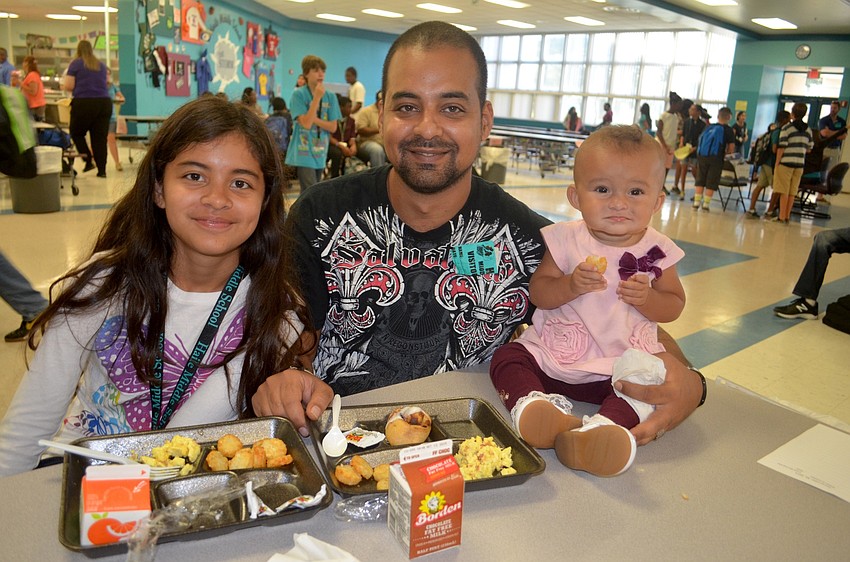 The Cuevas family — Michelle, Anibal and Anna — enjoy a meal together in the cafeteria.