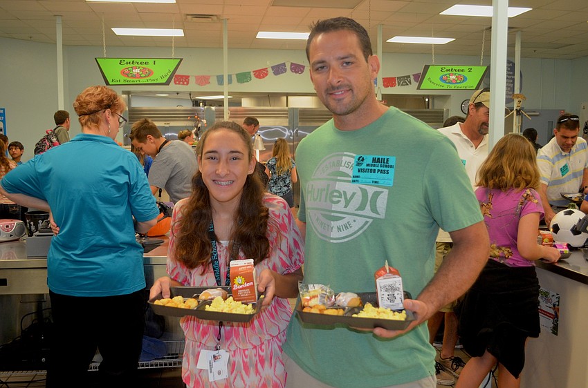 Katelynn Seeberg leads her dad, Ron, to a seat in the cafeteria.
