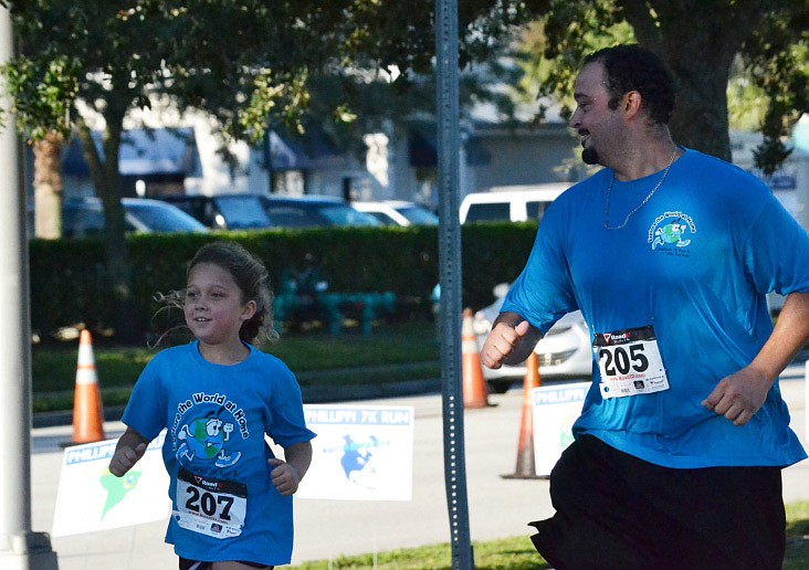 Stephanie Sanchez and her father Isaac approach the finish line at the Phillippi Shores Elementary 7K Run.