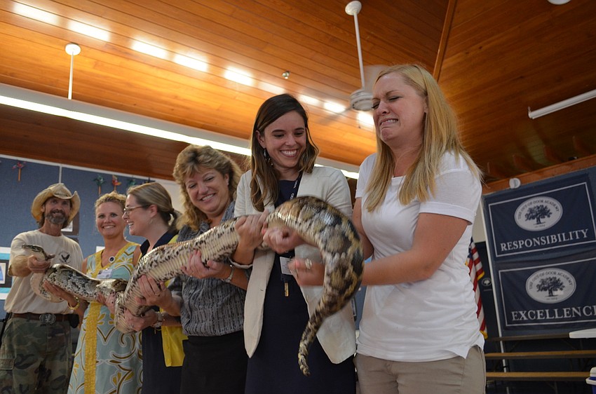 Teacher Jessica Urbans shows hesitation to hold the python.