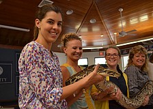ODA teacher Sarah Bryan holds Axel Rose a Burmese python.