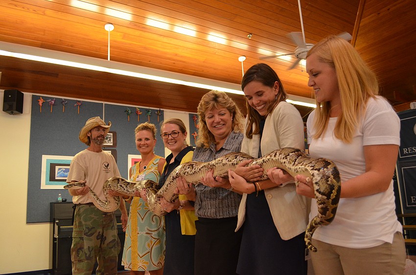 ODA teachers lend a hand in holding a Burmese python.