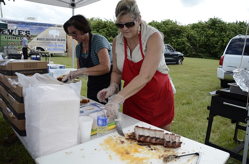 Valerie King chops up some ribs for the Green Apple Catering booth.