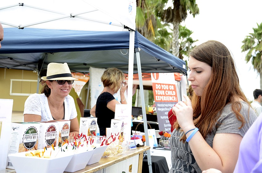 Shaina Robilotto samples some soft pretzel bites from Kim Livengood with Boardwalk Food Company.