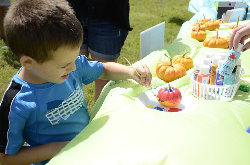 Ethan Helrigle paints a mini pumpkin.