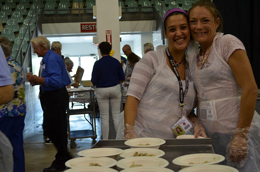 Kimberly Ellison and Madelyn Gillis hand out bowls of swamp cabbage.