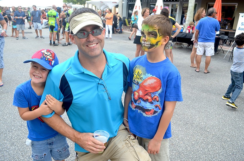 The Holmen family — Mason, Erik and Myles — support event participants from the sidelines.