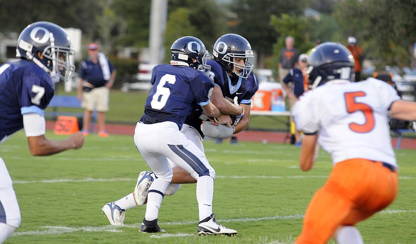 Freshman quarterback Anthony Squitieri hands the ball off to sophomore running back Dakota Dickerson.