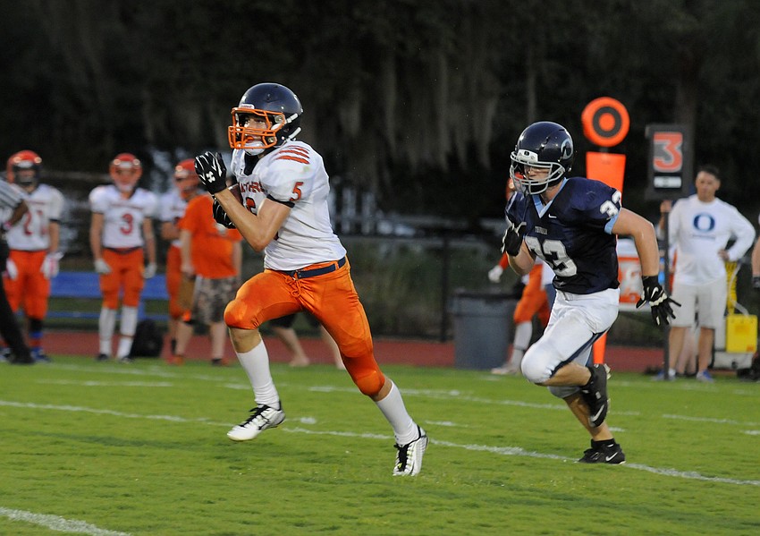 Bradenton Christian's Winston Spencer races past ODA lineman Chris Poole en route to a 47-yard touchdown.