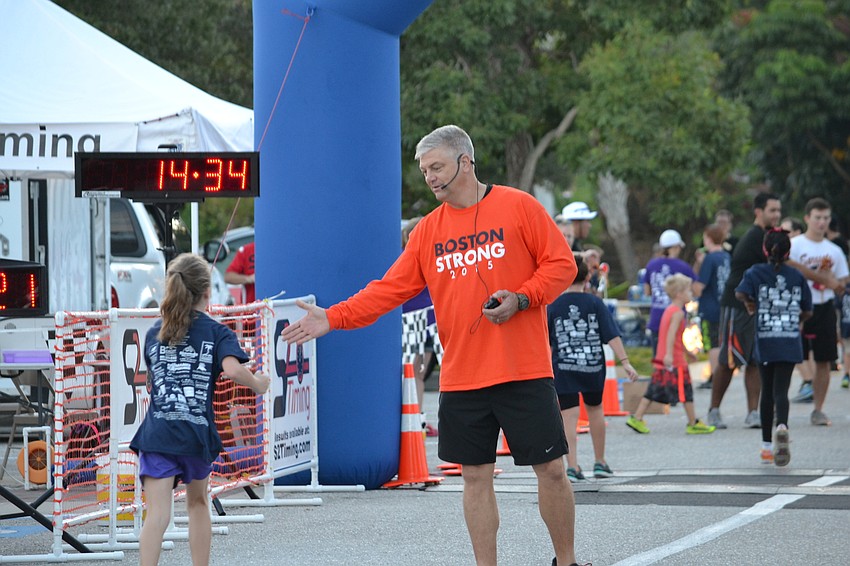 John Cox welcomes runners to the finish line.