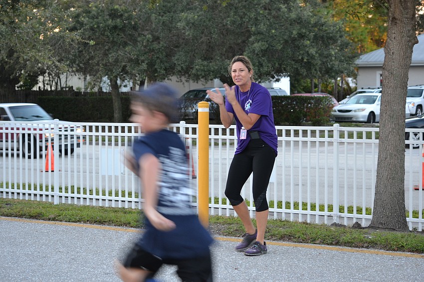 Phillippi Shores teacher Ginger Rosenberger cheers on participants as they reach the finish line.