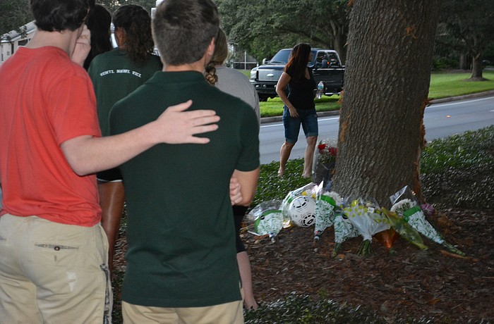 Friends said little as they placed flowers at the base of the tree.
