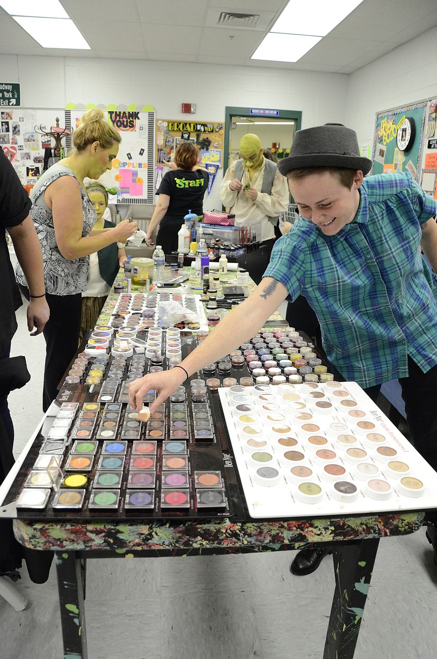 Casey Kelley grabs for a color in the plethora of theater makeup.