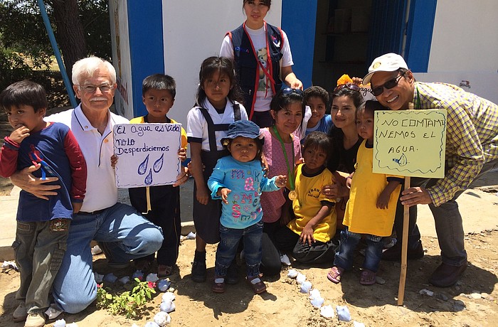 Ron Myers, left, with a handful of children from a water project community in Peru. Courtesy photo.