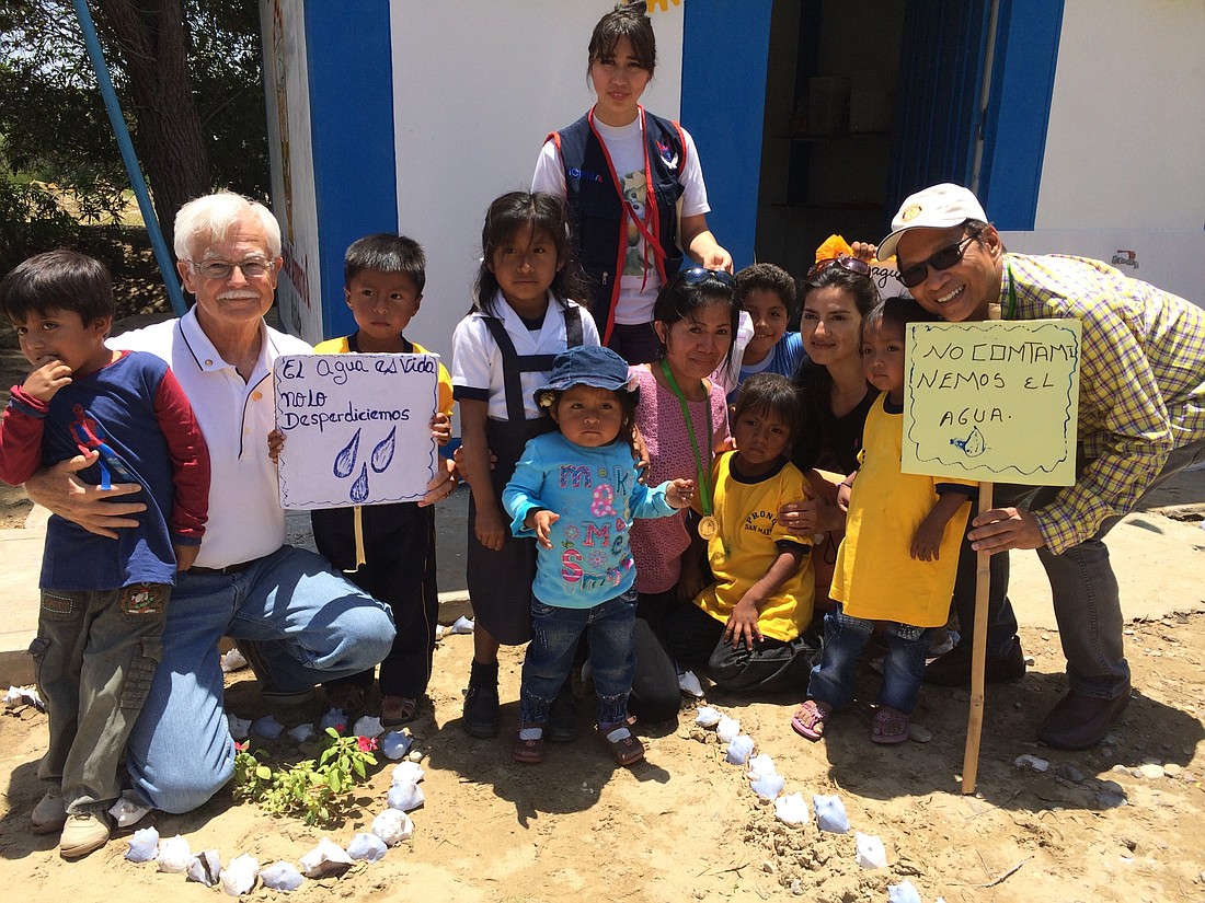 Ron Myers, left, with a handful of children from a water project community in Peru. Courtesy photo.