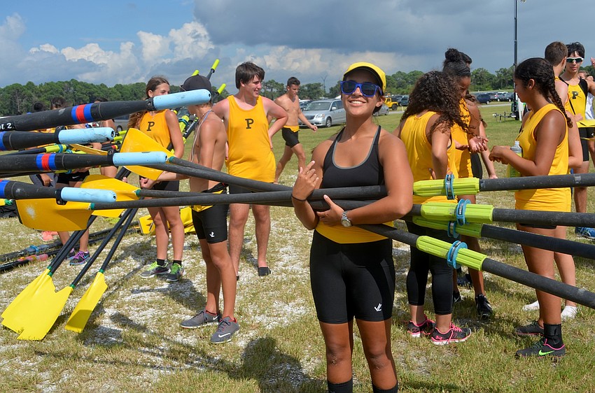 Amanda Pombar, of the Plant High rowing team, carries equipment  off the docks after a race.