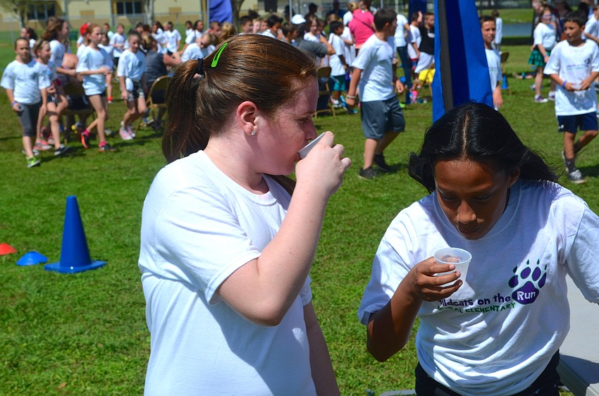 Friends and classmates Marenna Bohner and Emma Fletcher take a break to hydrate.