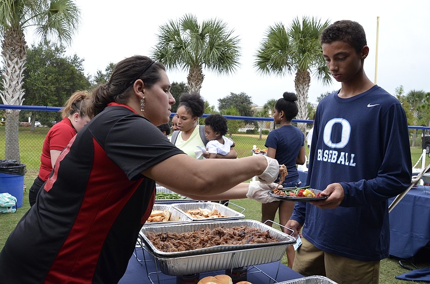 Dawn Jordan, a caterer with Lee Roy Selmon's, serves up dinner to Tai Gilbert, freshman.