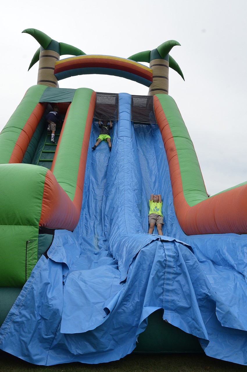 First-graders Phillip Spilka and Hayne Falck race down the slide.