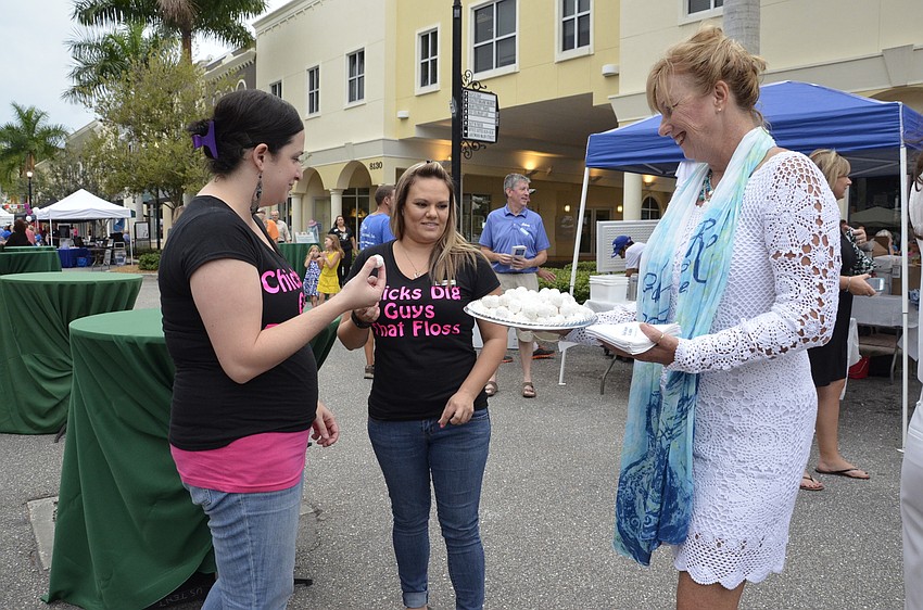 Angela Miller and Kelley Gursky with Cooper Creek Dental get a chocolate from Marcia Frost, a Realtor with Michael Saunders.